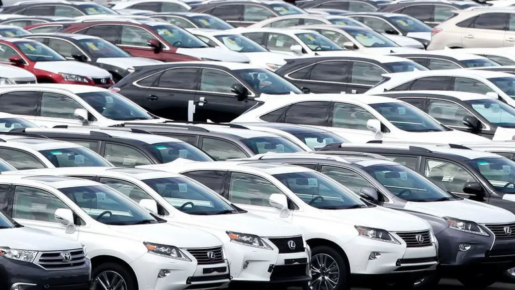 Ilustrasi mobil Toyota dengan latar pabrik sebagai gambaran penurunan penjualan global Toyota pada 2026.